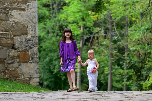 Two sisters walking in city park