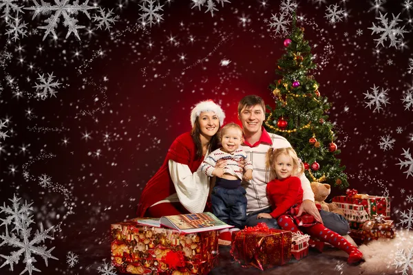Christmas family of four persons and fir tree with gift boxes