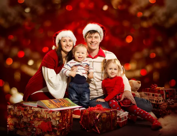 Christmas family of four persons happy smiling over red backgroud