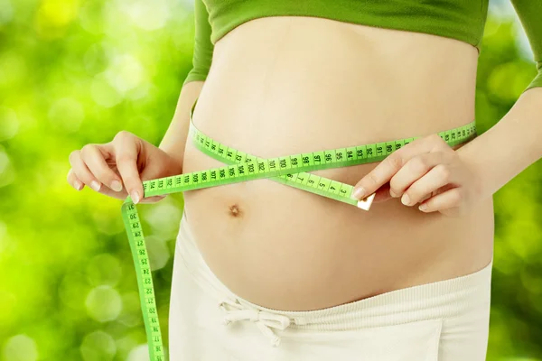 Pregnant belly, woman measure stomach. Prenatal health care concept