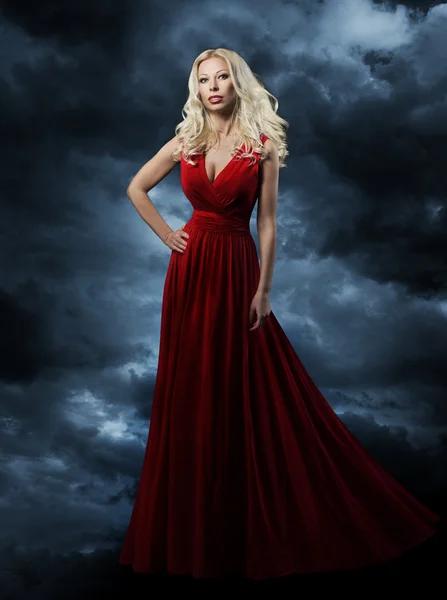 Woman in red dress over sky