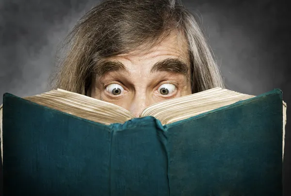 Senior reading open book, surprised old man, amazing eyes looking blank cover
