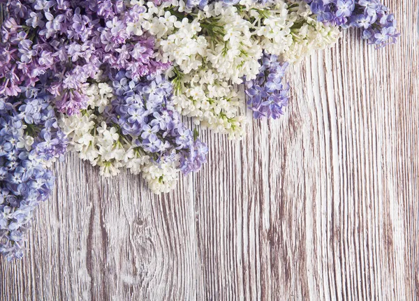 Lilac flowers on wood background, branch on wooden texture