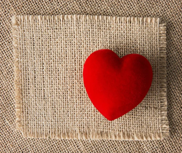 Red heart on burlap, sackcloth background. Valentines Day handmade card