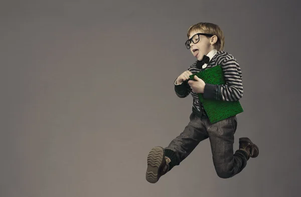 Child running back to school, funny kid portrait, jumping smart schoolboy with glasses and book