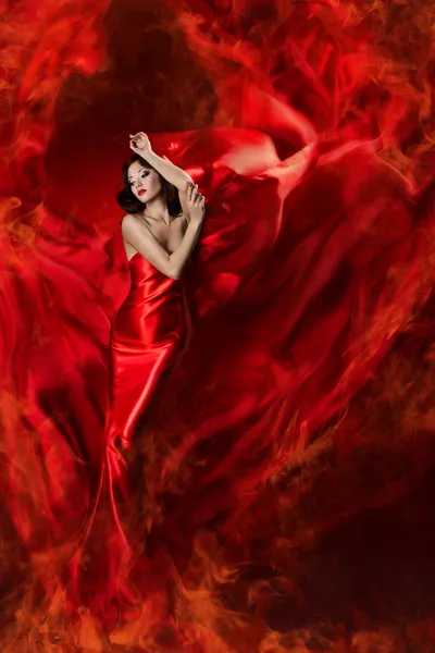 Beautiful woman in red waving silk dress as a fire flame.