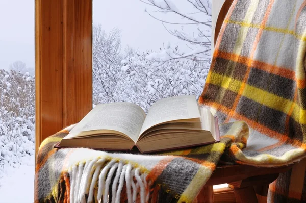 Book on a chair in winter, near the window