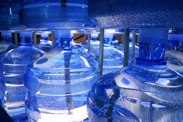 Producing big plastic bottles of water.