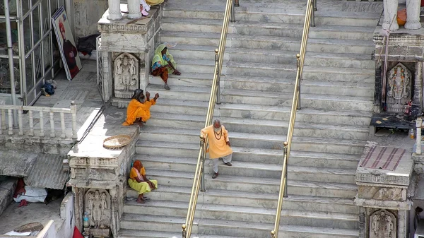 UDAIPUR, INDIA - APRIL, 2013: People sitting on stairs