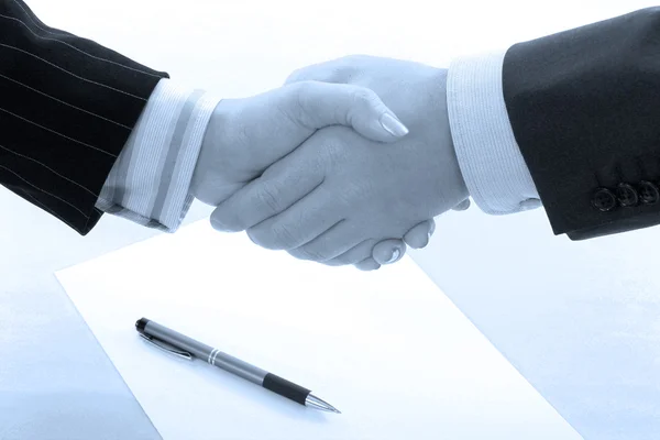 Business handshake deal in blue tone
