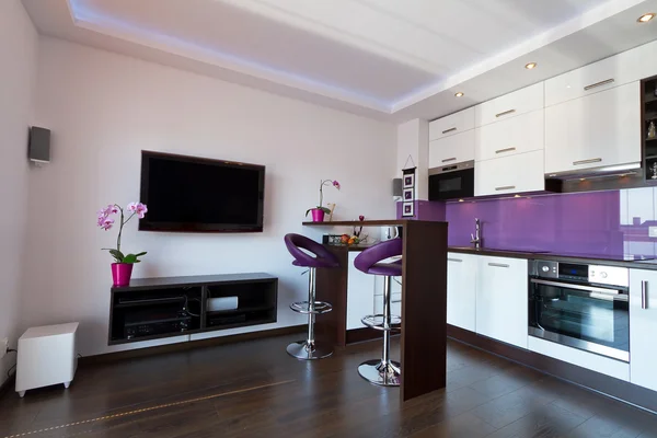 Modern living room with purple kitchen