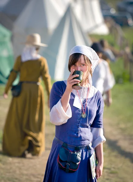 Medieval fashion, middle ages woman having a drink