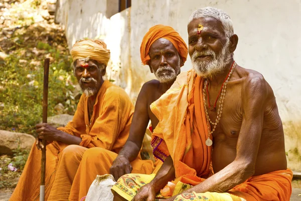 Holy Sadhu men in saffron color clothing blessing in Shiva Temple.