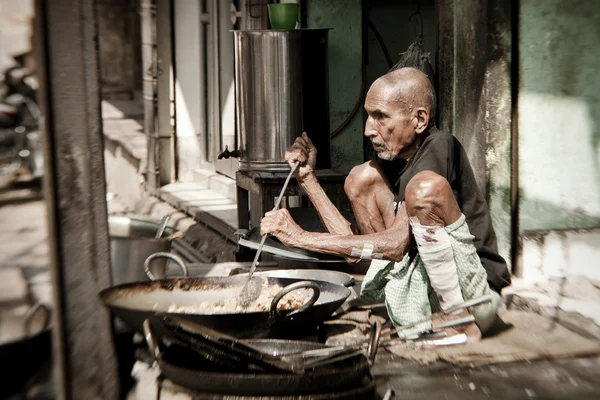 Man cooks meal for sale in street restaurant