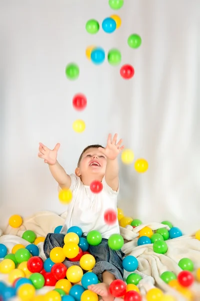 Cute boy playing colorful balls