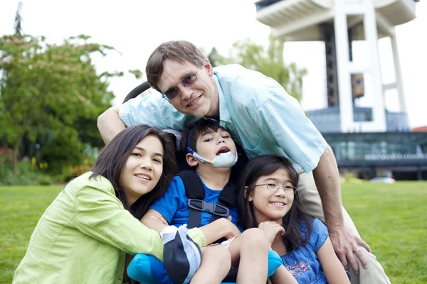 Disabled boy in wheelchair surrounded by family