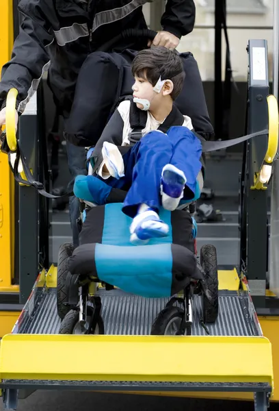 Disabled boy on school bus wheelchair lift