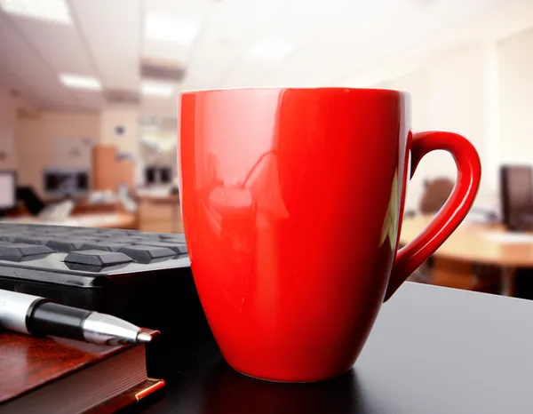 Red cup of coffee in office