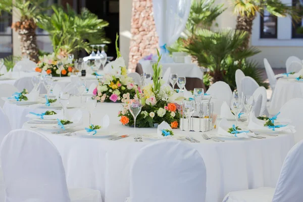 Catering table set service with silverware, fresh flowers and gl