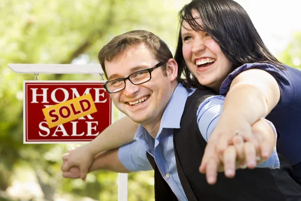 Happy Couple in Front of Sold Real Estate Sign