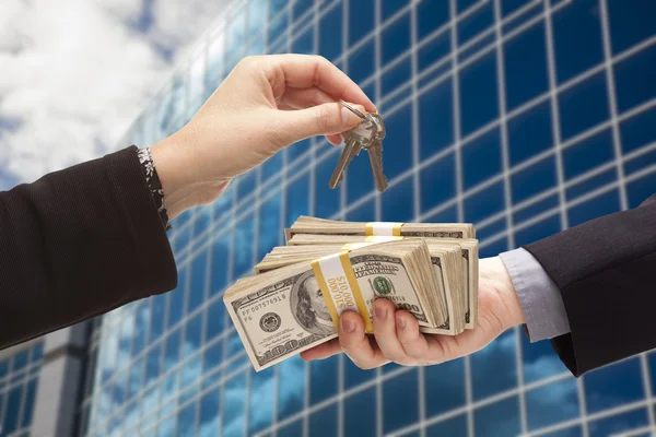 Handing Stack of Cash For Key and Corporate Building