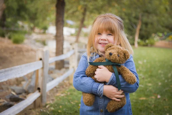 Cute Smiling Young Girl Hugging Her Teddy Bear Outside