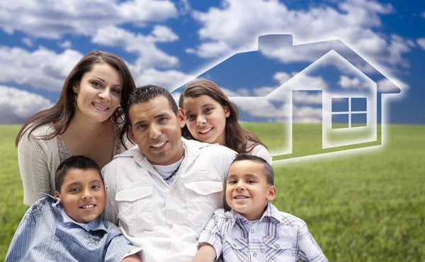 Hispanic Family Sitting in Grass Field with Ghosted House Behind