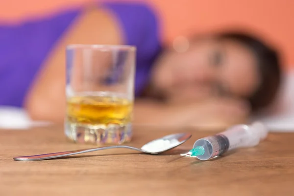 Addict with drugs,syringe and alcohol