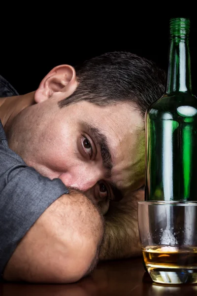 Drunk and depressed man drinking alone