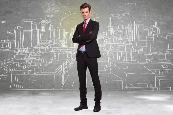 Business man standing in front of a sketch of a big city