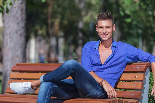 Man posing on bench in park