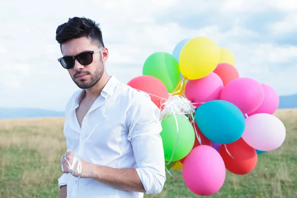 Closeup of casual man with balloons and sunglasses