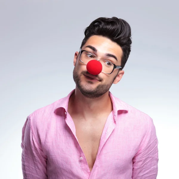 Fashion young man with red nose looks away