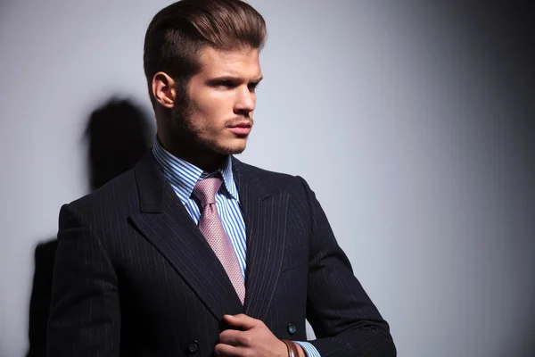 Side view of a sexy young man in classic suit and tie