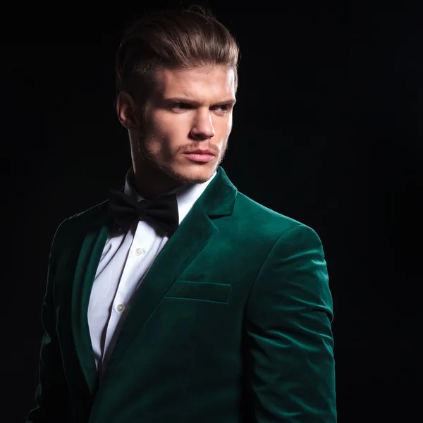 Man in a green velvet suit looking away