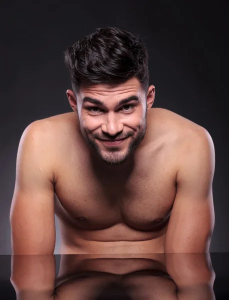 Naked young man smiles at you