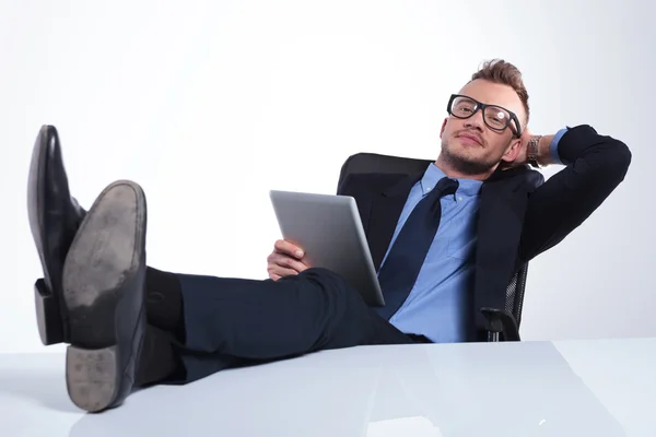 Business man relaxes with tablet in hand