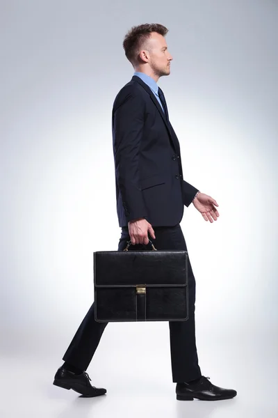 Business man walks with suitcase