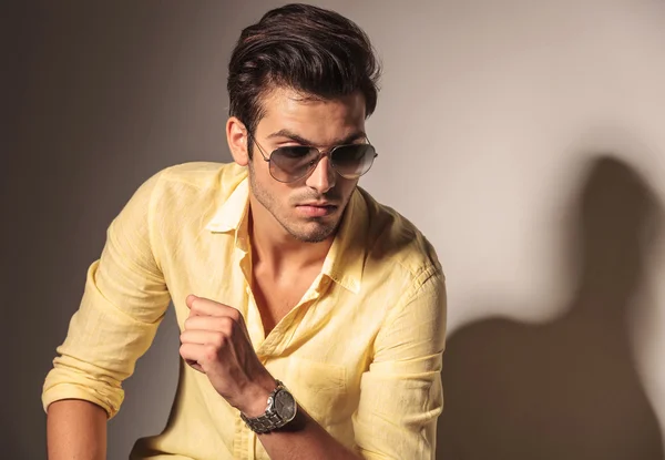 Attractive sexy man wearing sunglasses and yellow shirt