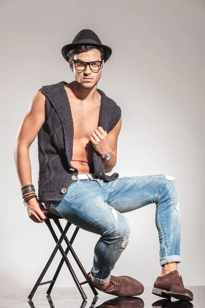 Sexy man sitting on a chair and posing