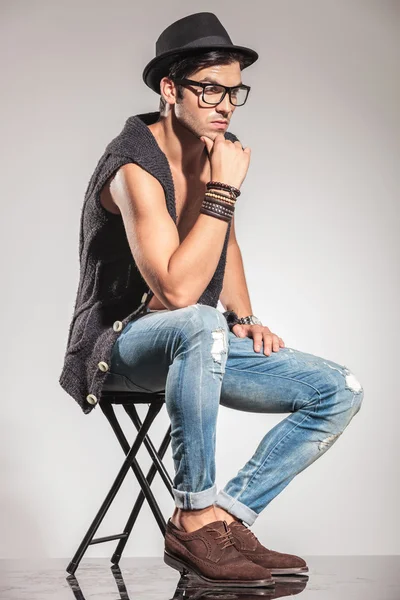 Side view of a seated pensive young man