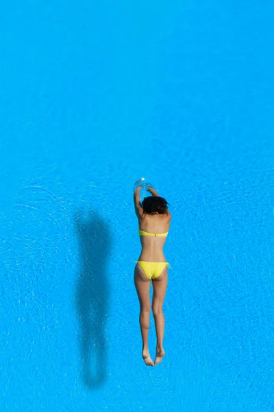 Top view of a girl diving in the pool