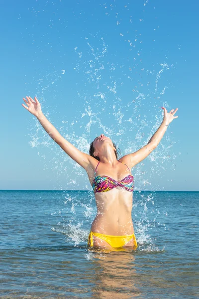 Beauty Model Girl Splashing Water in the ocean