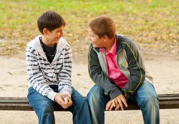 Two teenage friends talking in the park