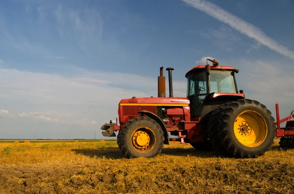 Red tractor on the agricultural field