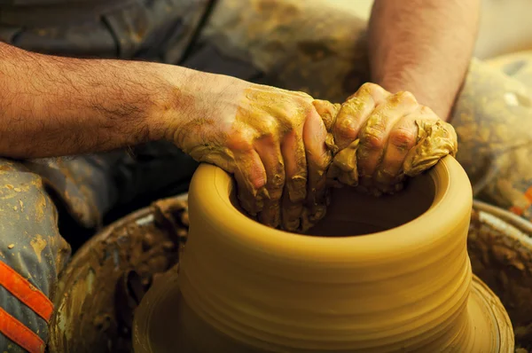 Craftsman making vase on pottery wheel