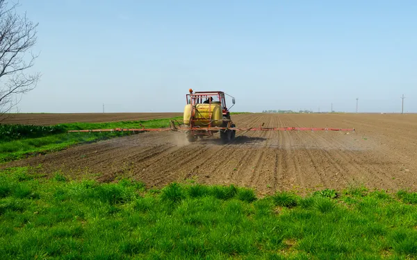 Tractor sprinkling pesticides againt pests