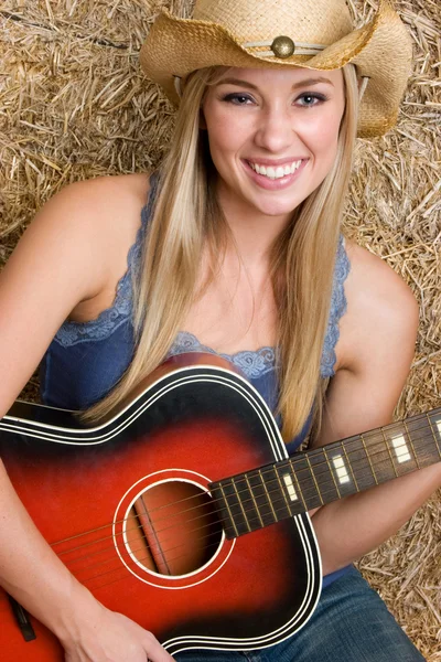 Blonde cowgirl playing guitar
