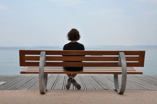 Loneliness teenager sitting on a bench