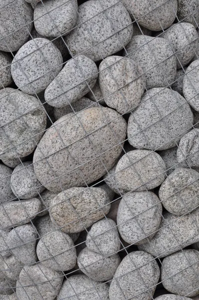 Round stones in a steel container